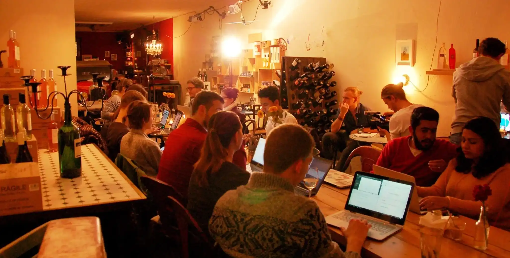 Mehrere Personen sitzen gesellig am Tisch und arbeiten an Laptops